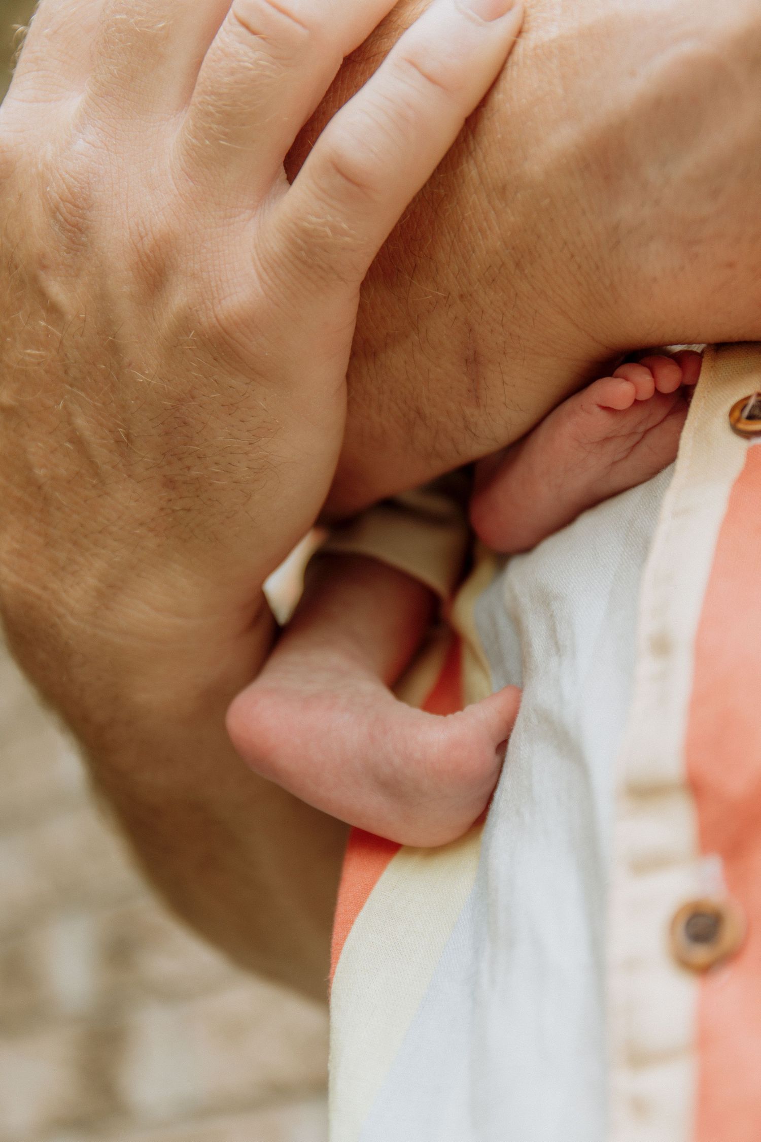 Kawartha Lakes Newborn Photography Session.
Close up detail photo of dad holding baby girl and her feet are against his chest
