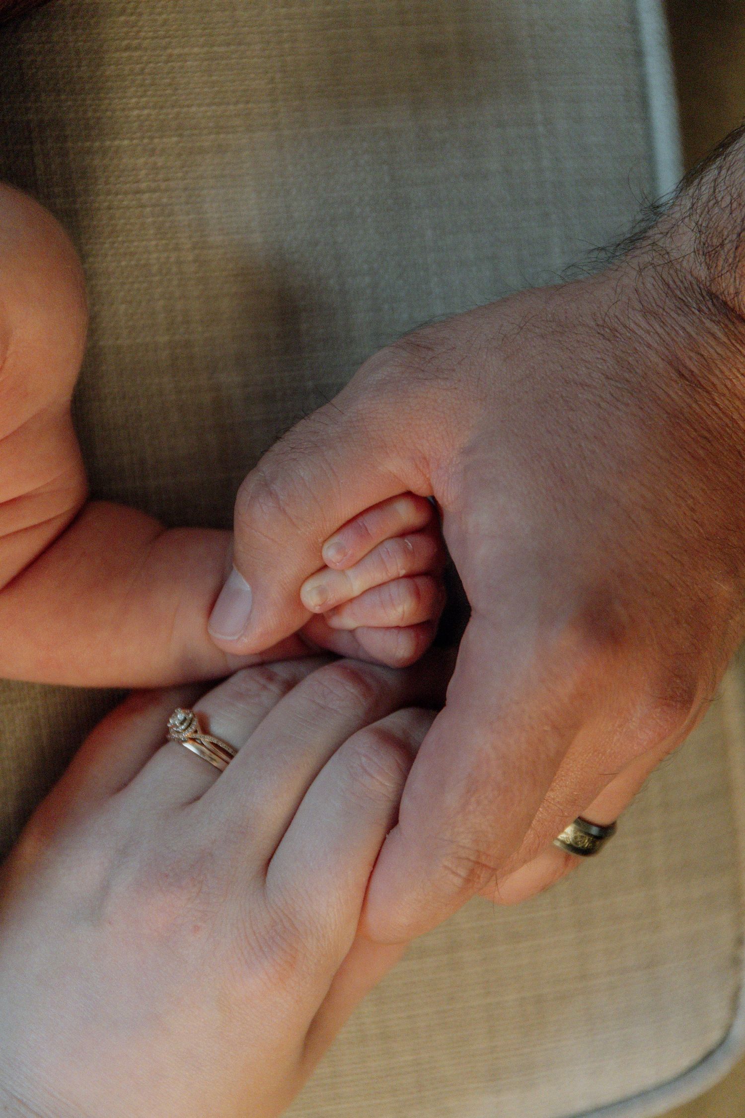 Kawartha Lakes Newborn Photography Session.
Close up detail photo of mom and dad holding hands together with their newborn baby girl