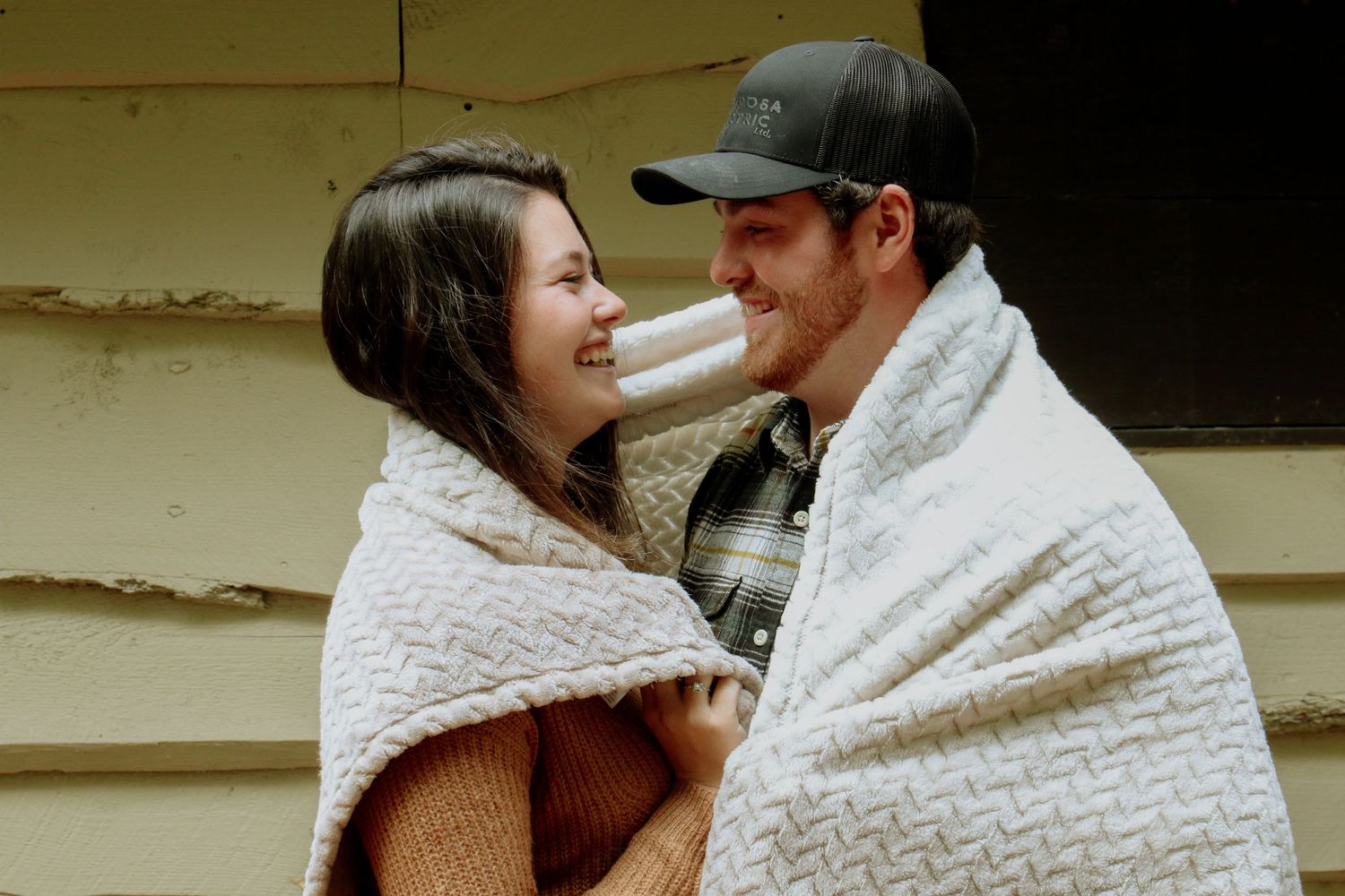 Kawartha Lakes Couple Photography Session.
Boyfriend and girlfriend hugging and looking at eachother with a blanket wrapped around shoulders