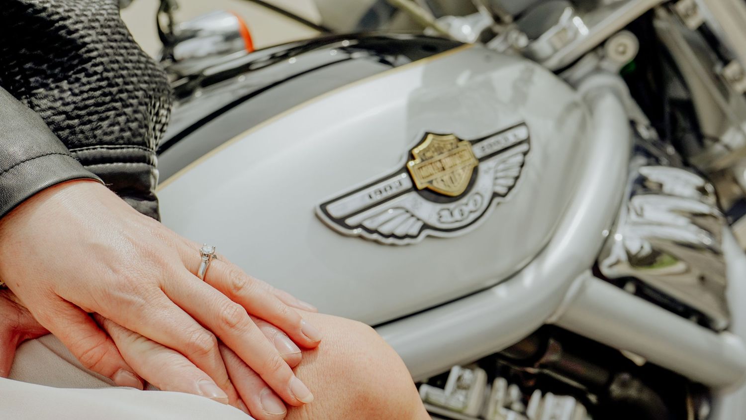 Kawartha Lakes Couples Engagement Photography Session.
Fiancés holding hands on Harley Davidson motorcycle showing off engagement ring