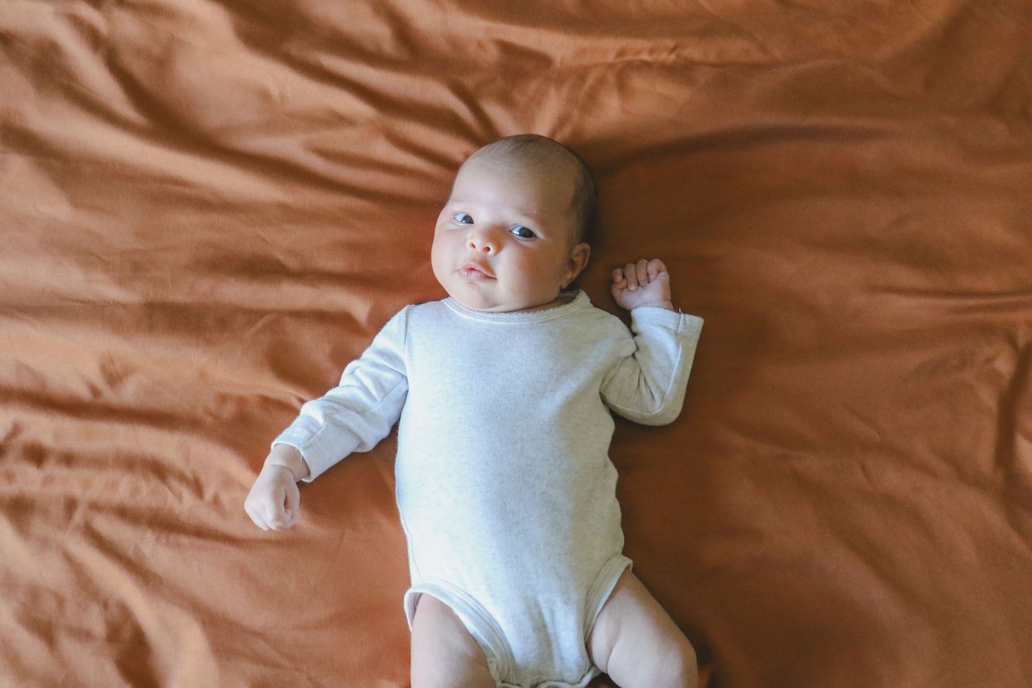 Kawartha Lakes Newborn Photography Session.
Newborn baby girl laying on bed looking at camera
