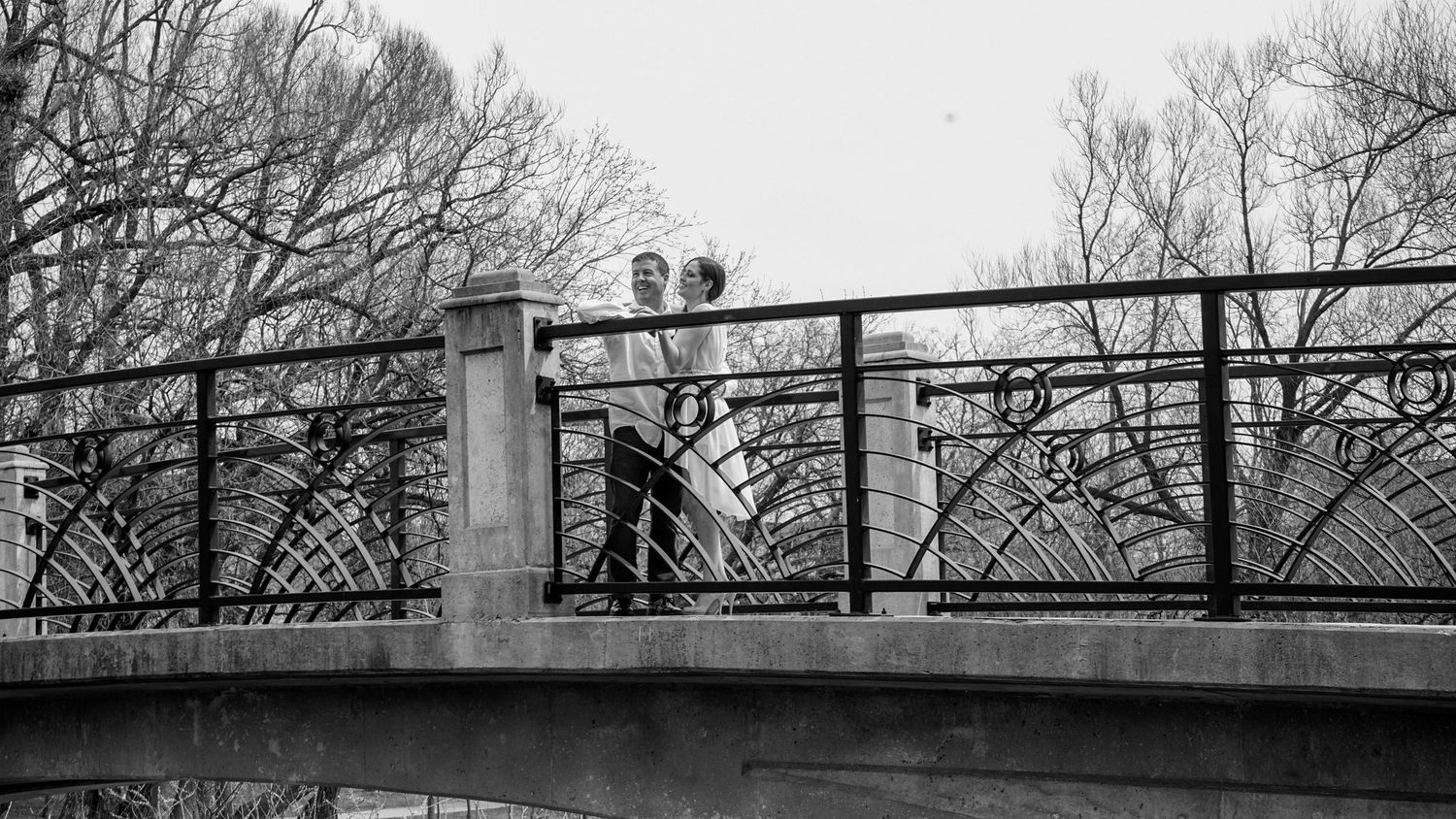 Kawartha Lakes Couples Engagement Photography Session.
Fiancé and fiancée laughing and smiling together standing on a bridge black and white