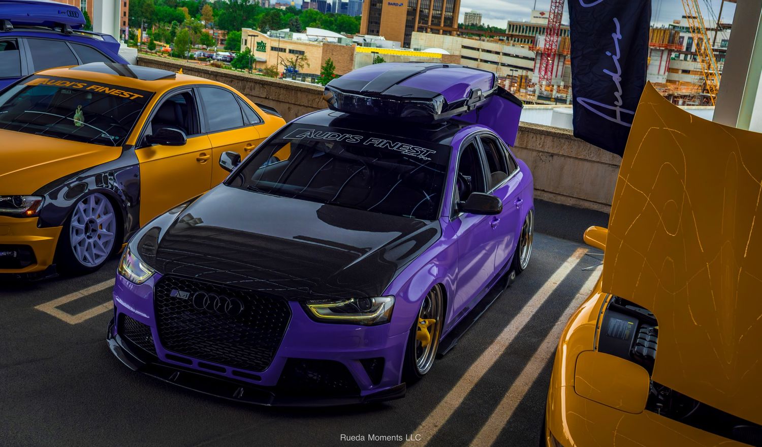 Purple widebody Audi RS3 with carbon hood at car show event.