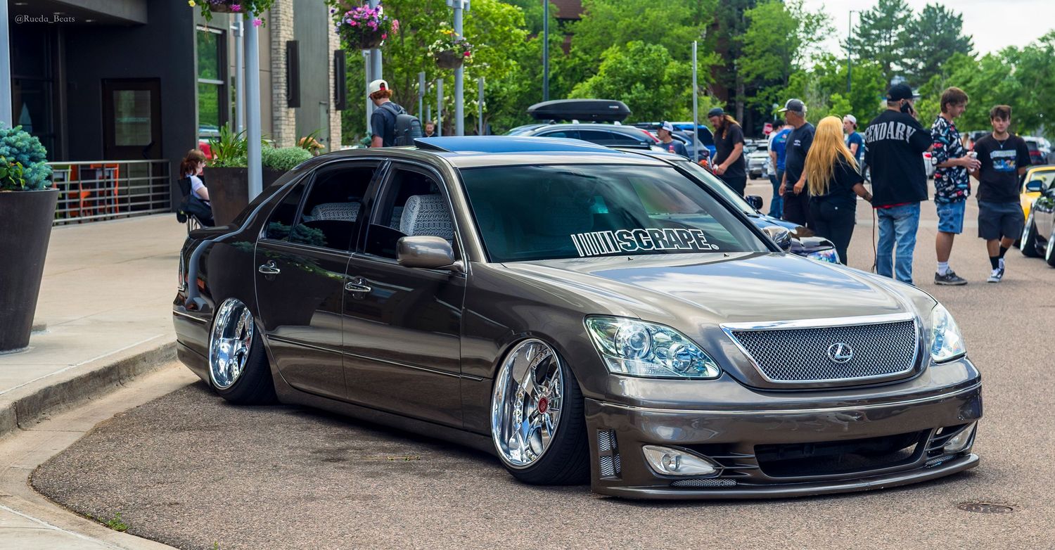Slammed bagged Lexus LS430 in gunmetal gray with wide body kit at a car meet.
