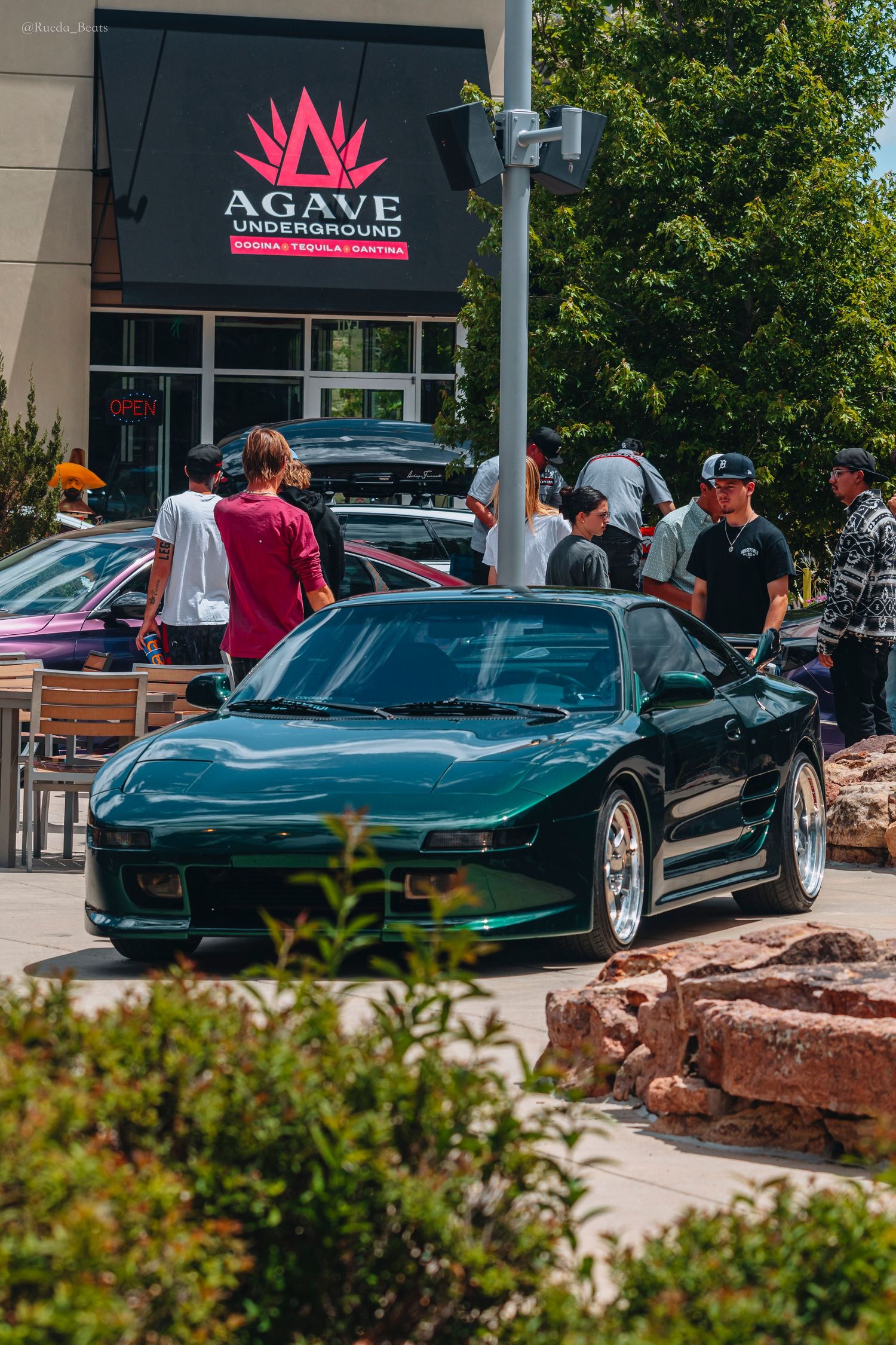 Green Honda NSX parked outside Agave Underground at a sunny car meet event.