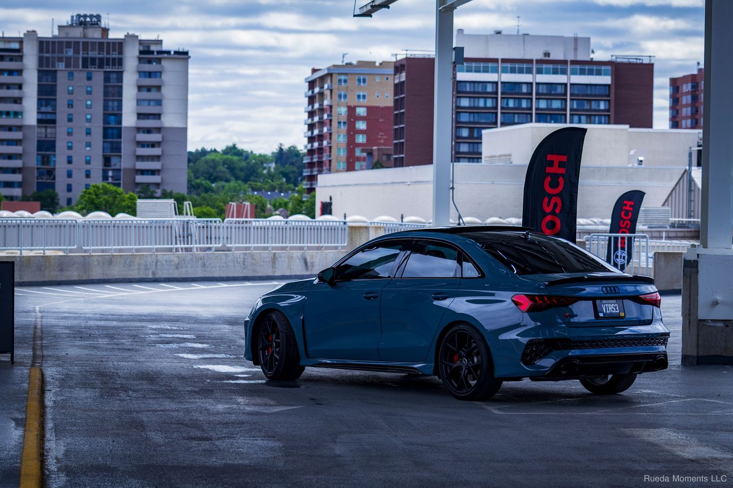 Blue Audi RS3 wagon lowered on black wheels at a car show.