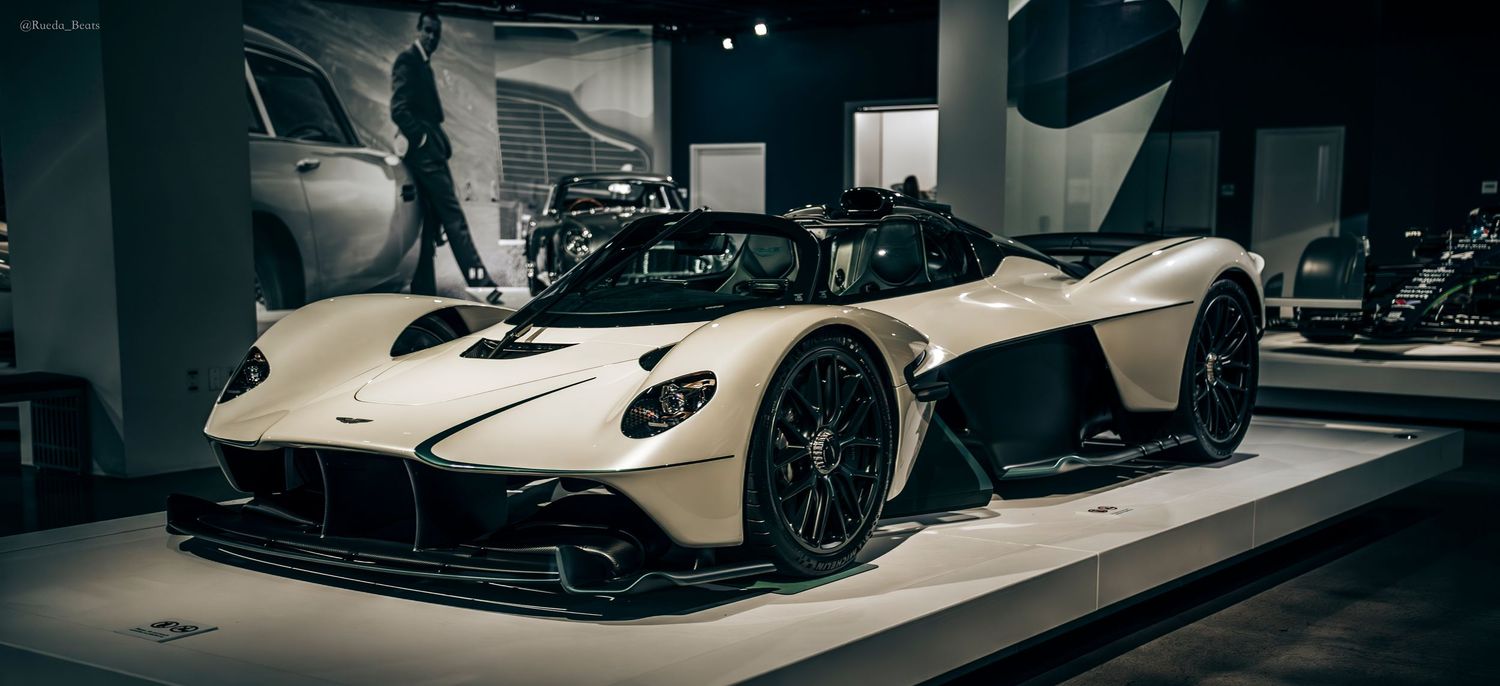 White Aston Martin Valkyrie hypercar with carbon fiber details displayed in a museum.