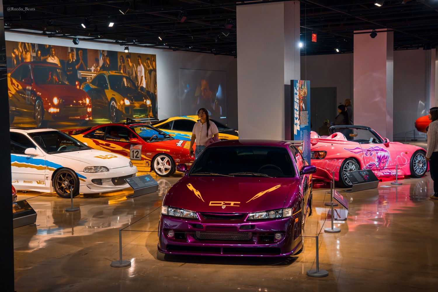 Collection of colorful Fast and Furious movie cars on display at an automotive museum.