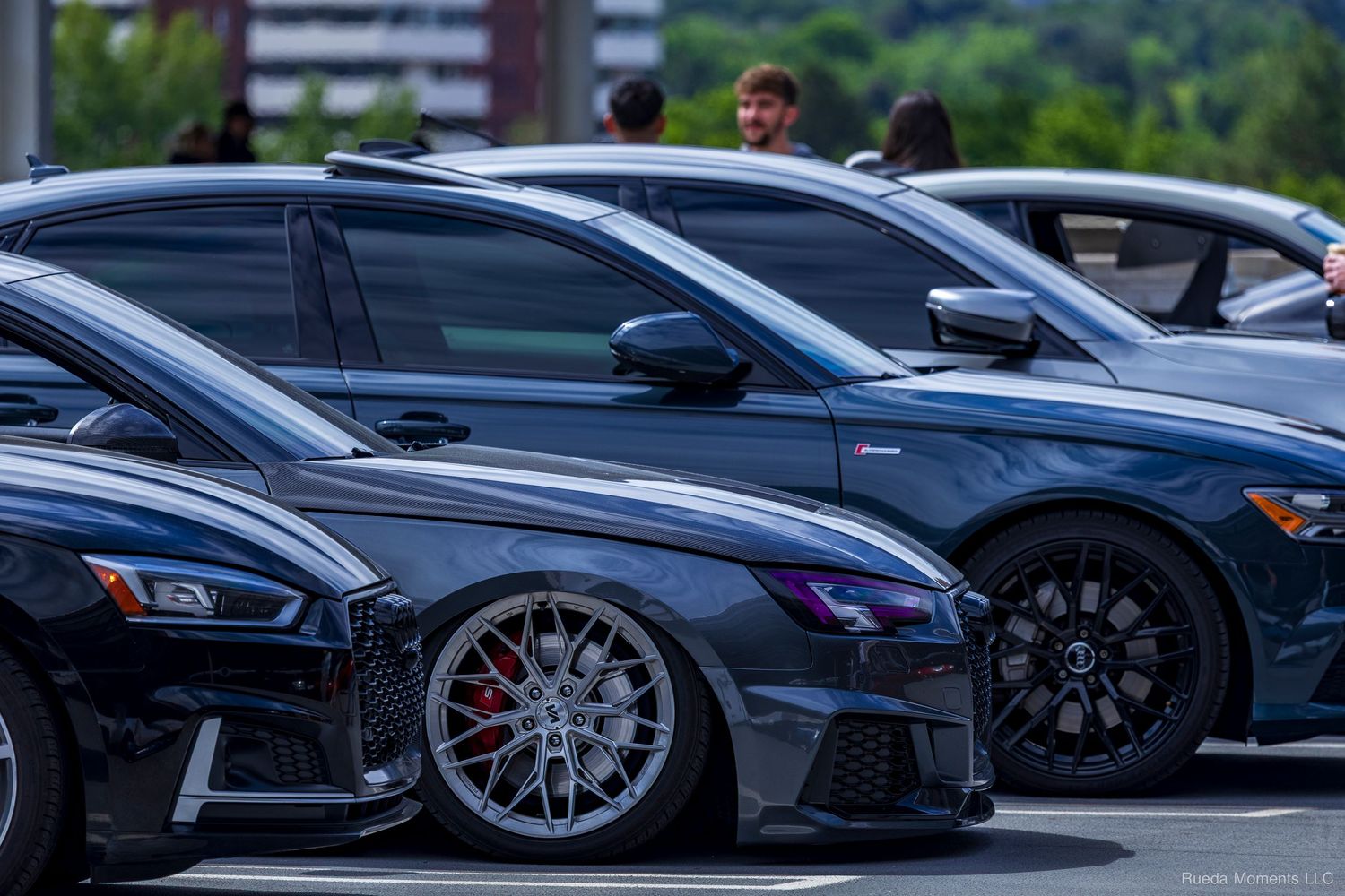 Lowered Audi RS3 with large silver wheels and red brake calipers at a car meet.
