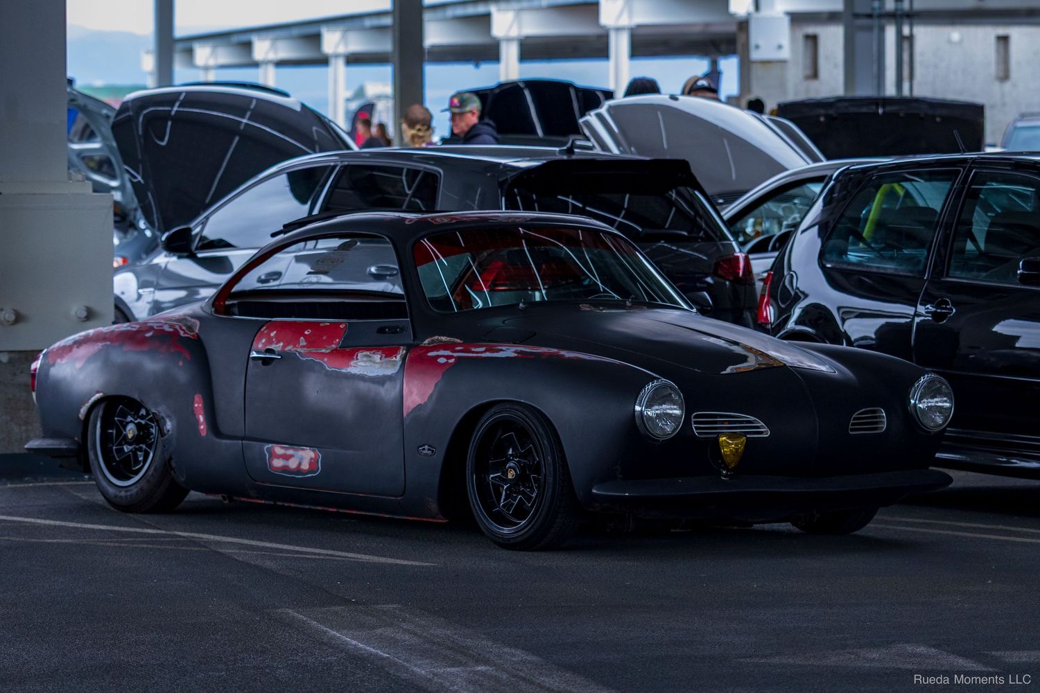 Custom matte black vintage Porsche 356 hot rod parked at an outdoor car meet.