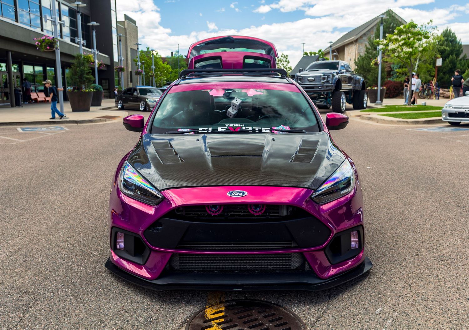 Modified purple Ford Focus RS with carbon hood and roof rack at a car meet.