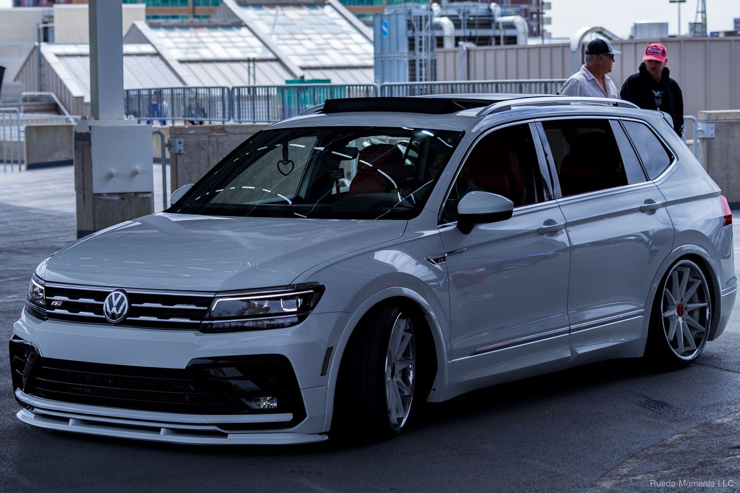 White VW Tiguan R-Line lowered on custom wheels at a car show.