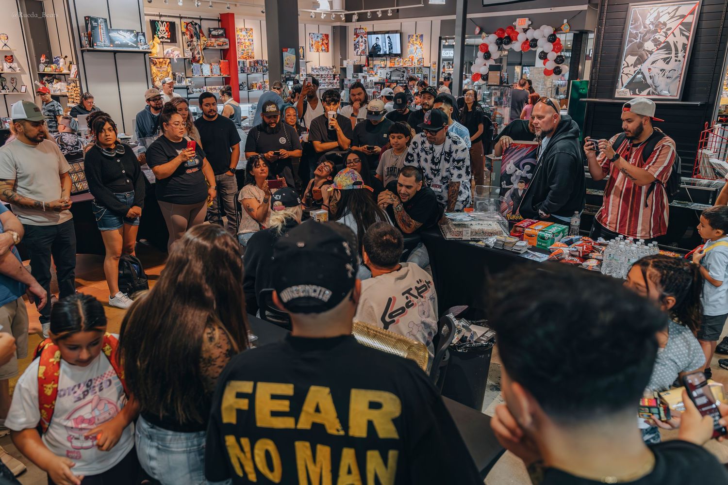 Large crowd gathered inside a store for a trading card signing event.