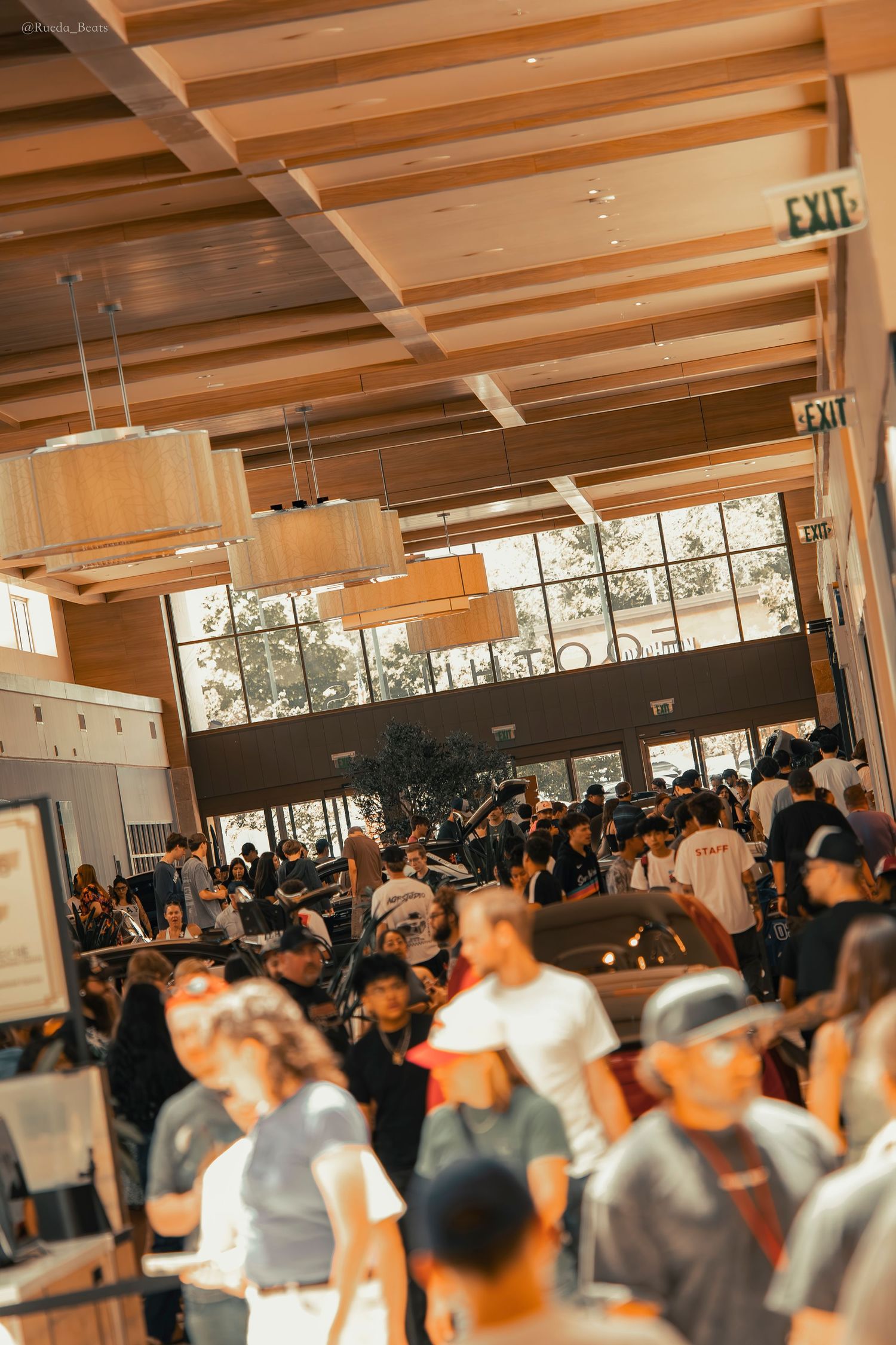 Large crowd of people gathered inside a modern building at a busy event.