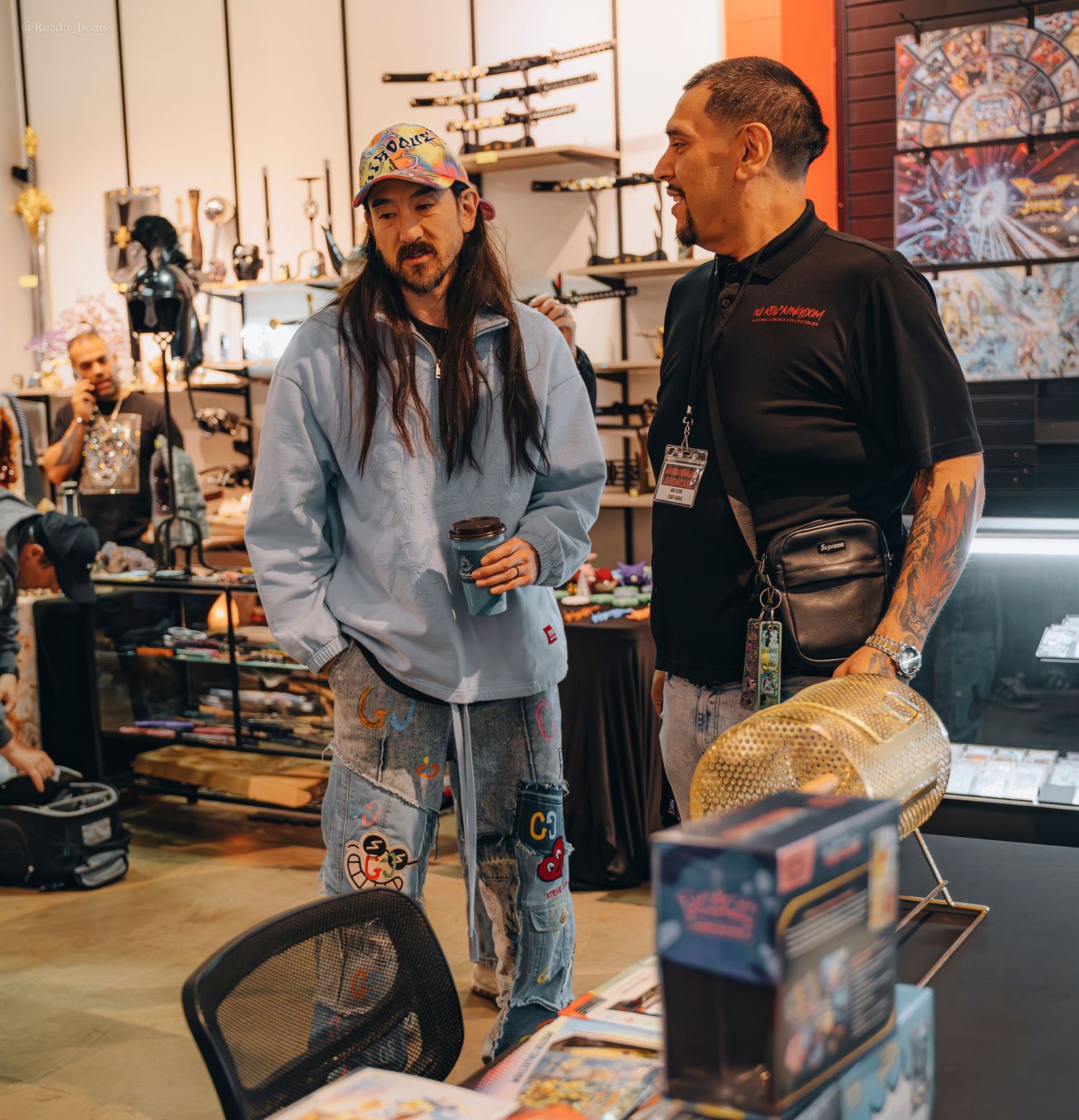 Two men conversing inside eclectic retail shop filled with collectibles and art.