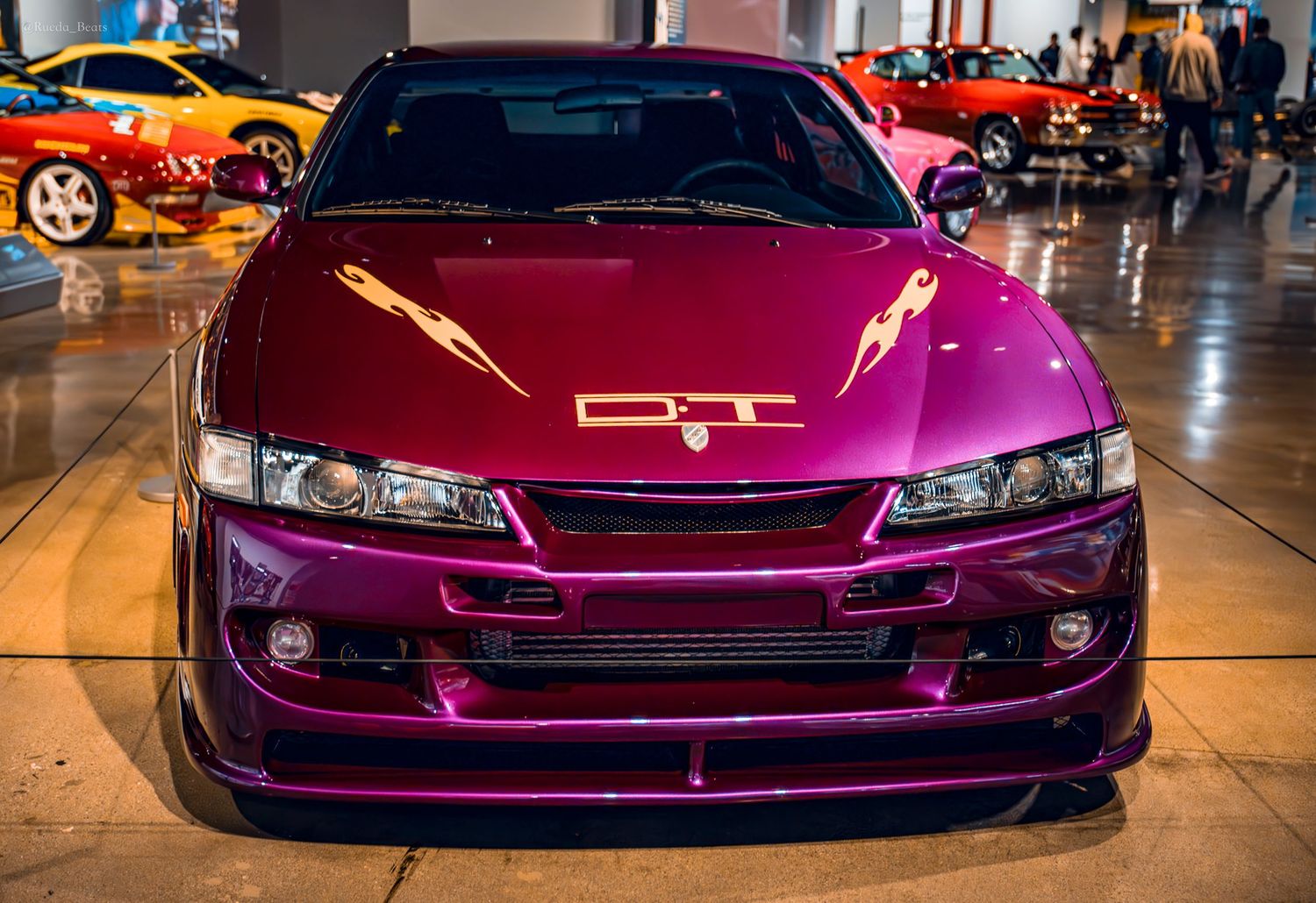 Front view of vibrant purple Nissan S14 with GT badge on display at car museum.