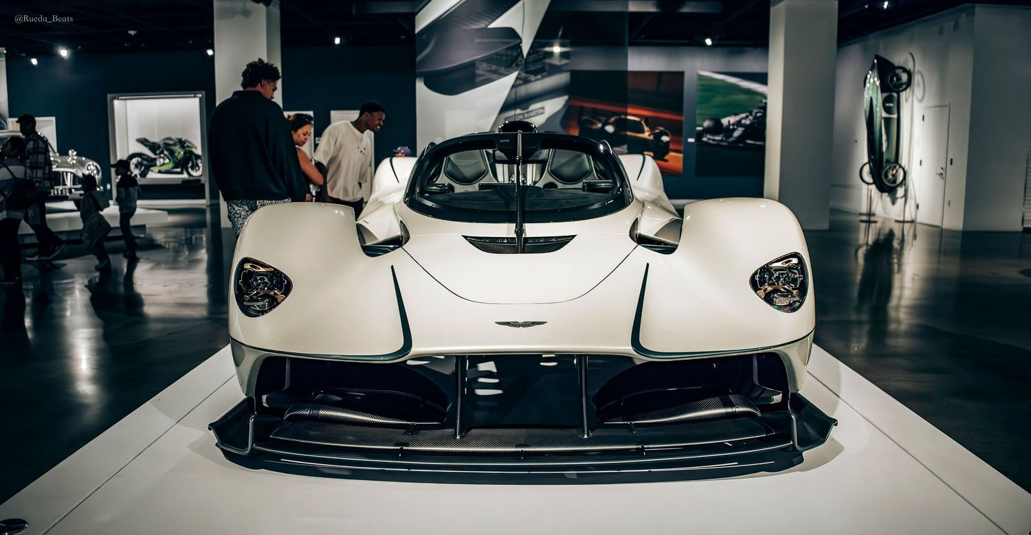Front view of a white Aston Martin Valkyrie hypercar on display at an auto show.