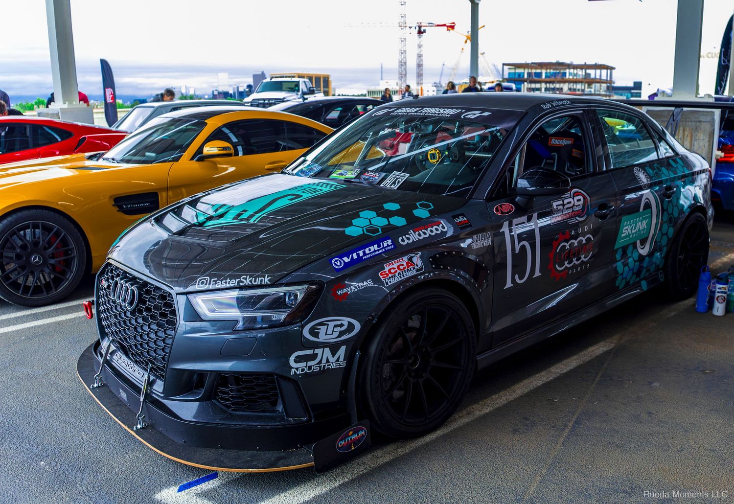 Black Audi RS3 race car number 151 with custom livery and aero kit at a motorsport event.