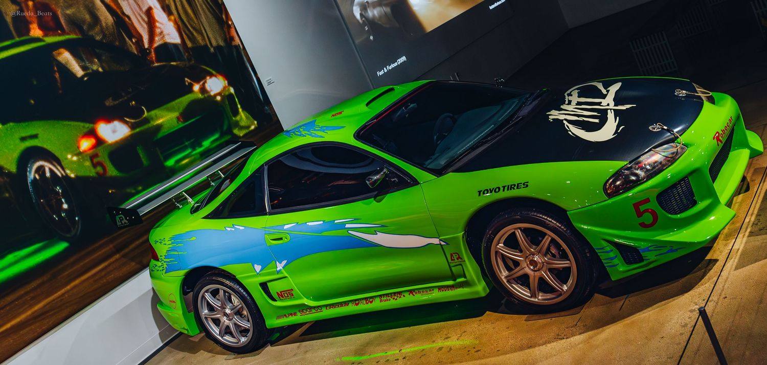 Lime green Mitsubishi Eclipse with blue accents and large spoiler from Fast and Furious on display.