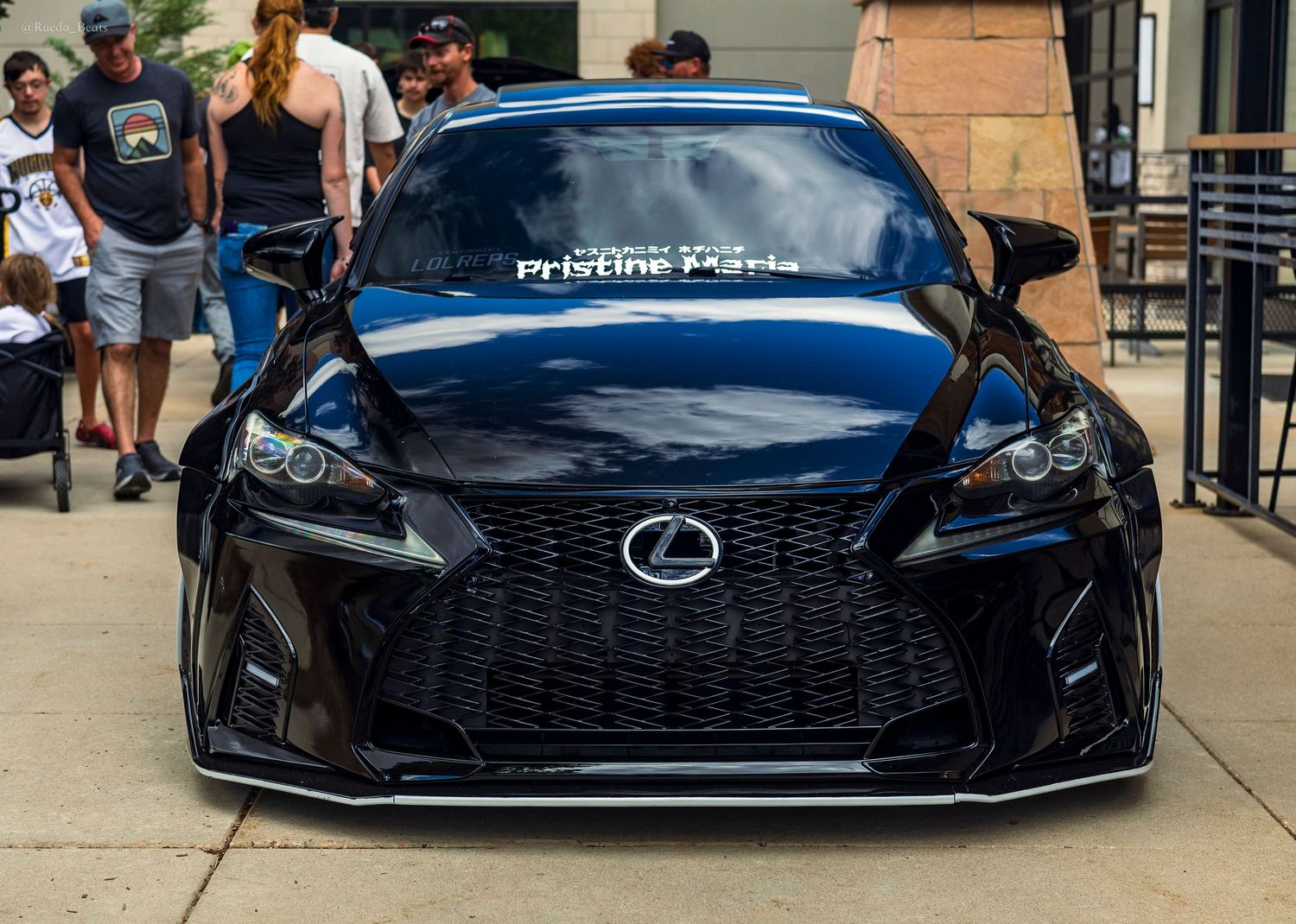 Sleek black Lexus RC F with aggressive front bumper and Pristine Parts branding at an outdoor show.