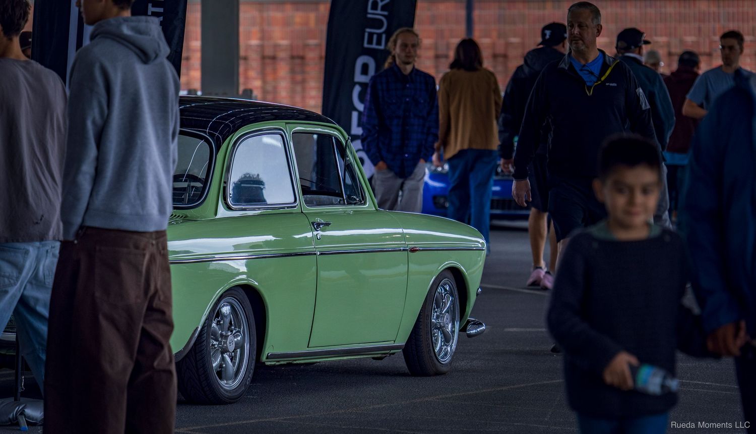 Vintage light green Volkswagen Type 3 on display at an evening automotive car meet.