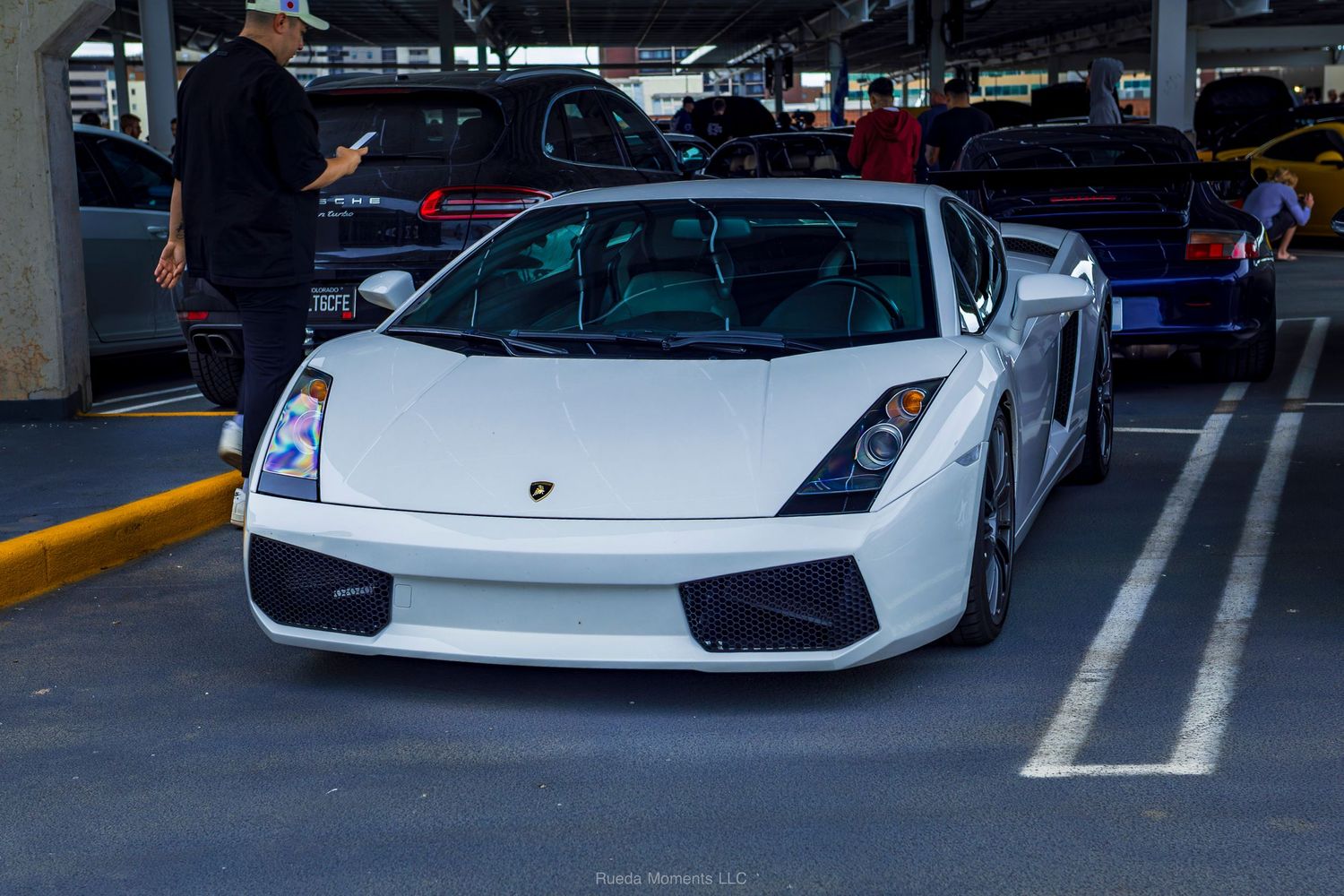 White Lamborghini Gallardo sports car parked at an outdoor car show event.