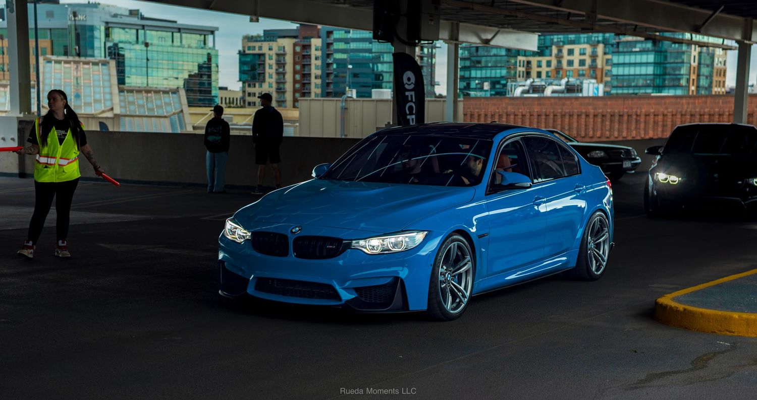 Yas Marina Blue BMW M3 F80 parked at an outdoor automotive enthusiast event.