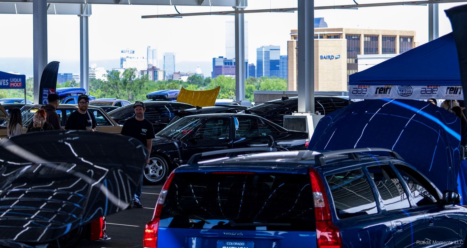 Interior view of a car dealership showroom filled with various vehicles on display under bright lighting.