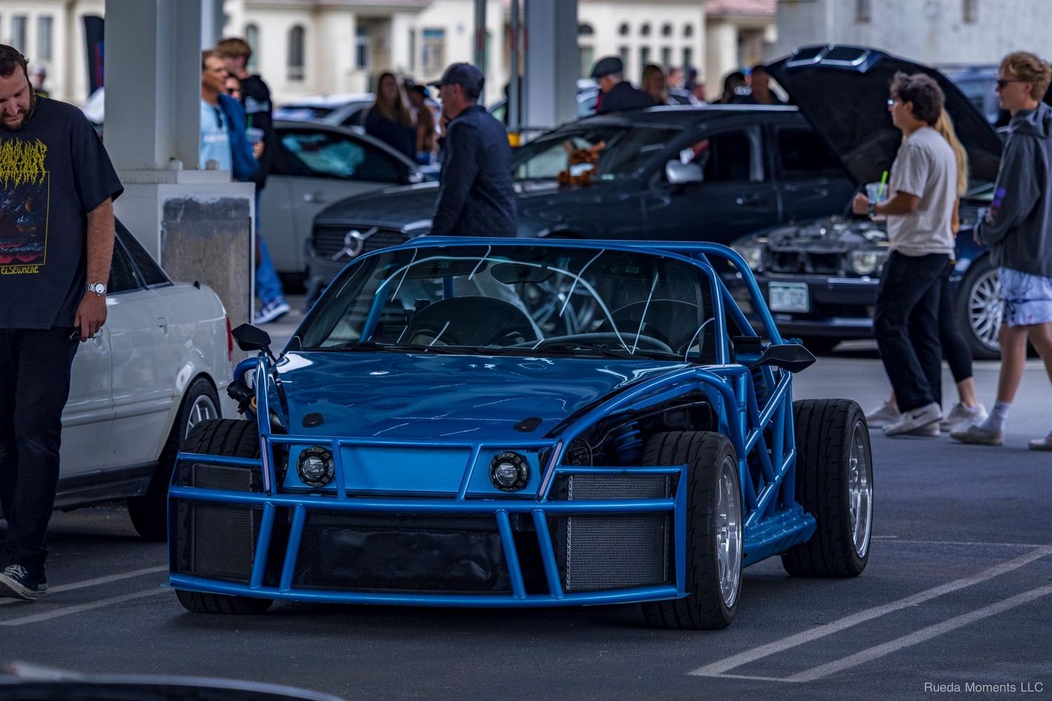 Custom blue tube-frame race car on display at an outdoor automotive car meet event.