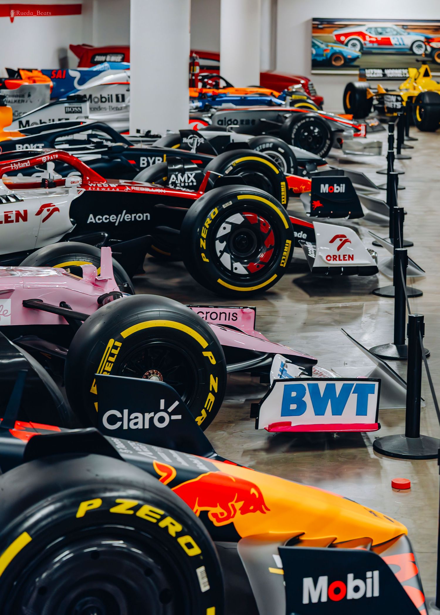 Collection of Formula 1 cars from multiple teams displayed in a motorsport museum.