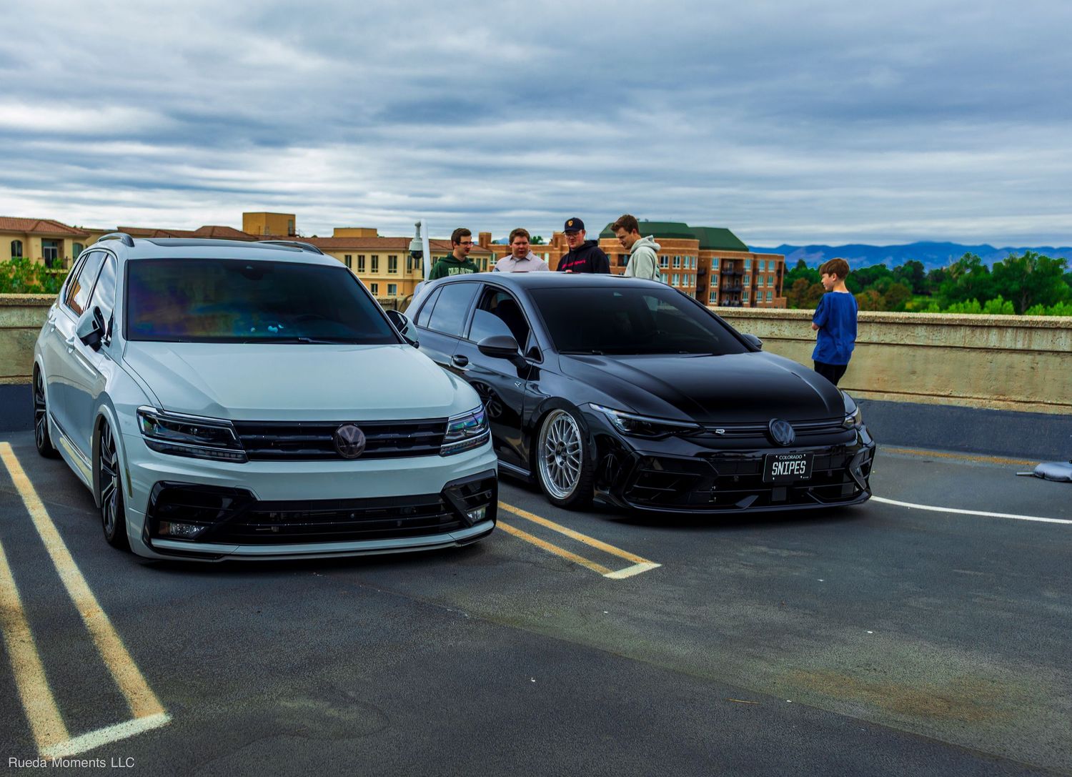 Lowered white VW Tiguan and black Honda Civic parked side by side at a rooftop car meet.