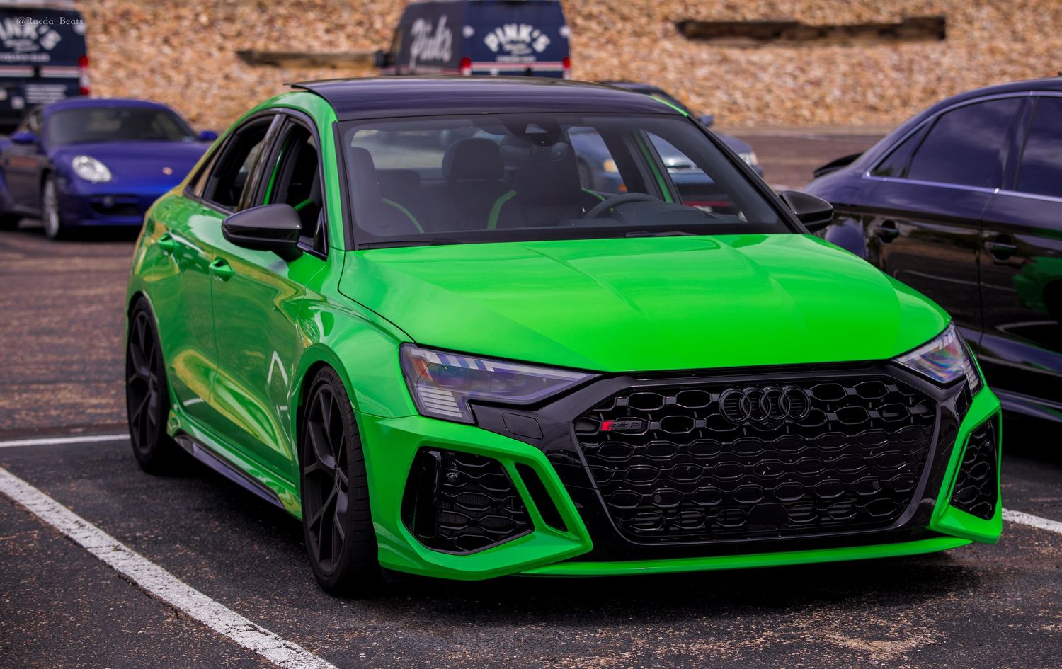 Bright green Audi RS3 parked at an outdoor car meet.