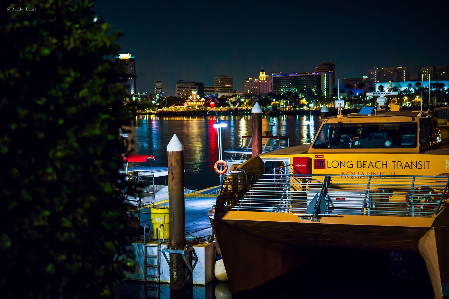 Long Beach Transit ferry boat docked at pier with glowing city skyline at night.