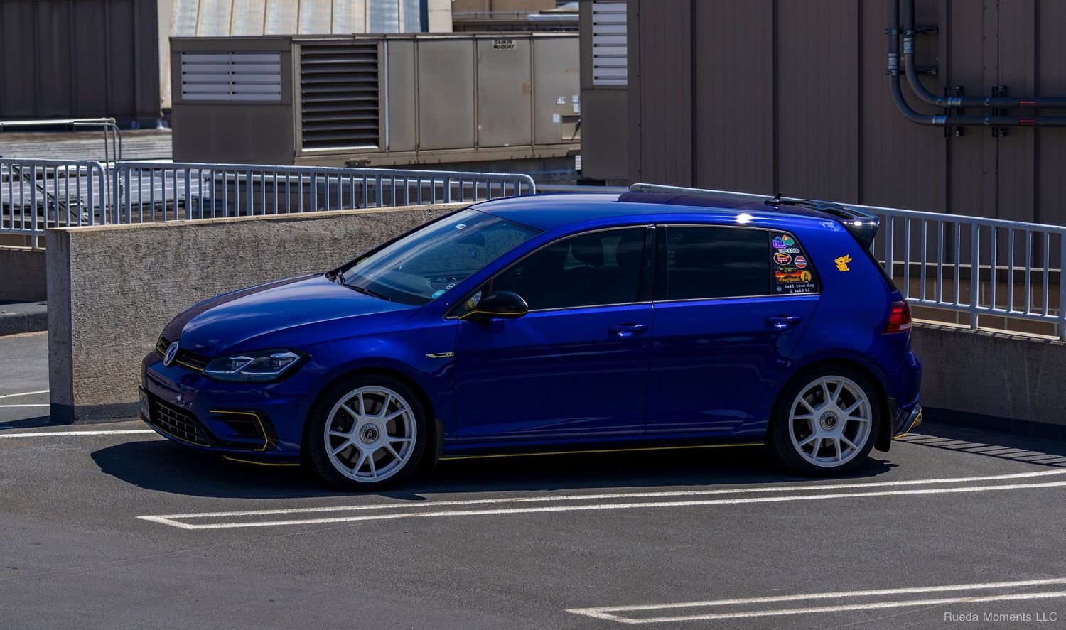 Blue Volkswagen Golf R hatchback parked in a lot showcasing clean euro styling.