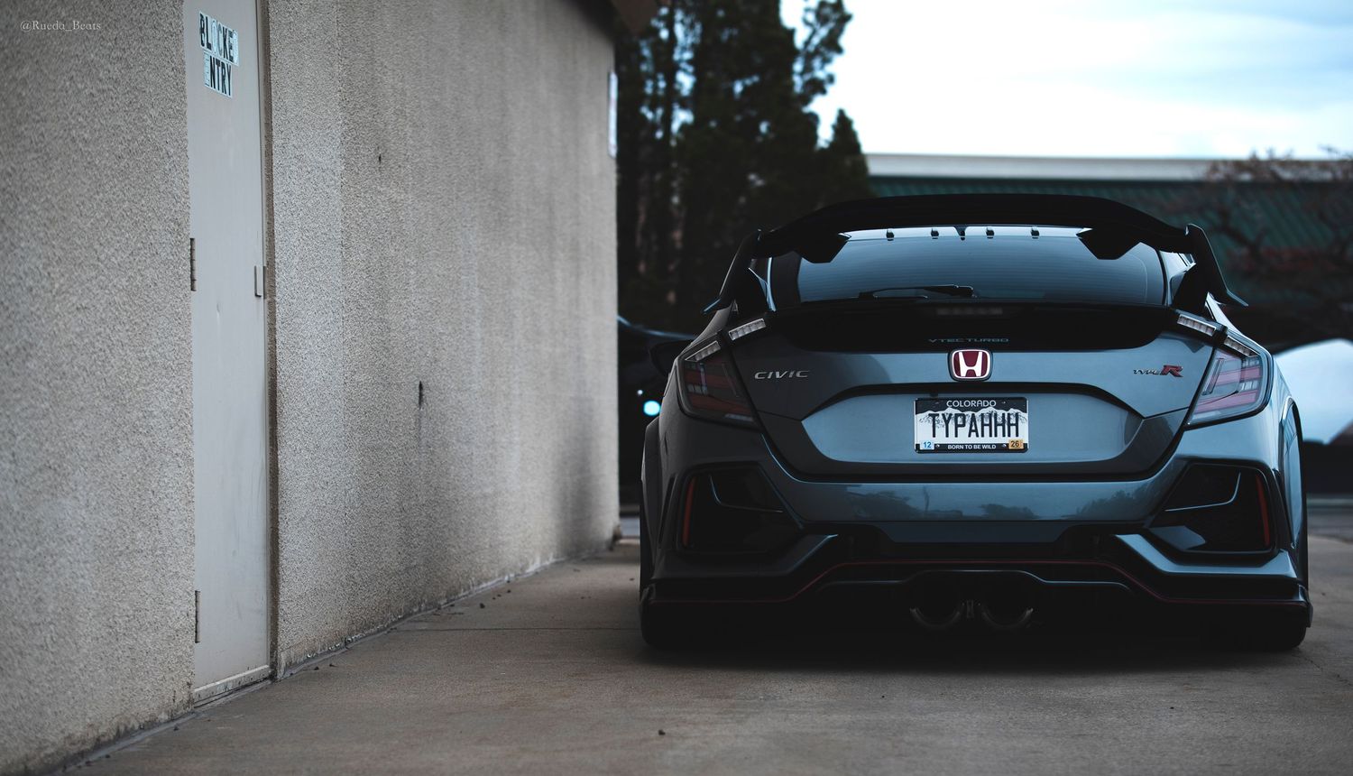 Rear view of a black Honda Civic Type R with a large spoiler.