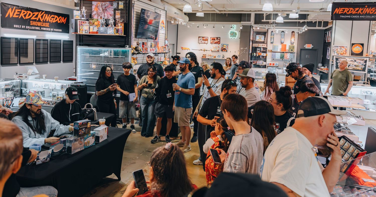 Crowd gathered around tables at Nerdz Kingdom collectibles store event.