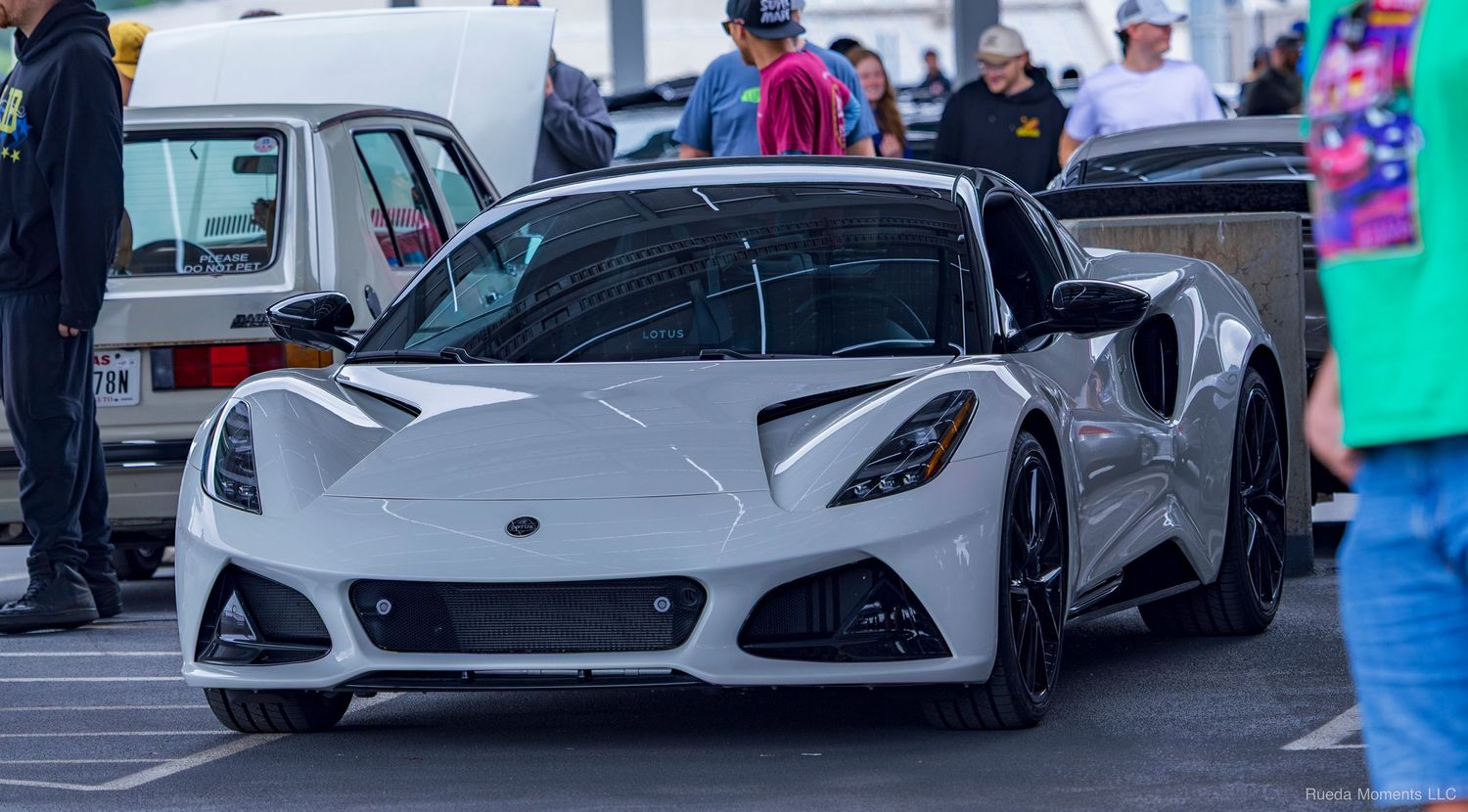 White Lotus Emira sports car parked at an outdoor automotive enthusiast event.
