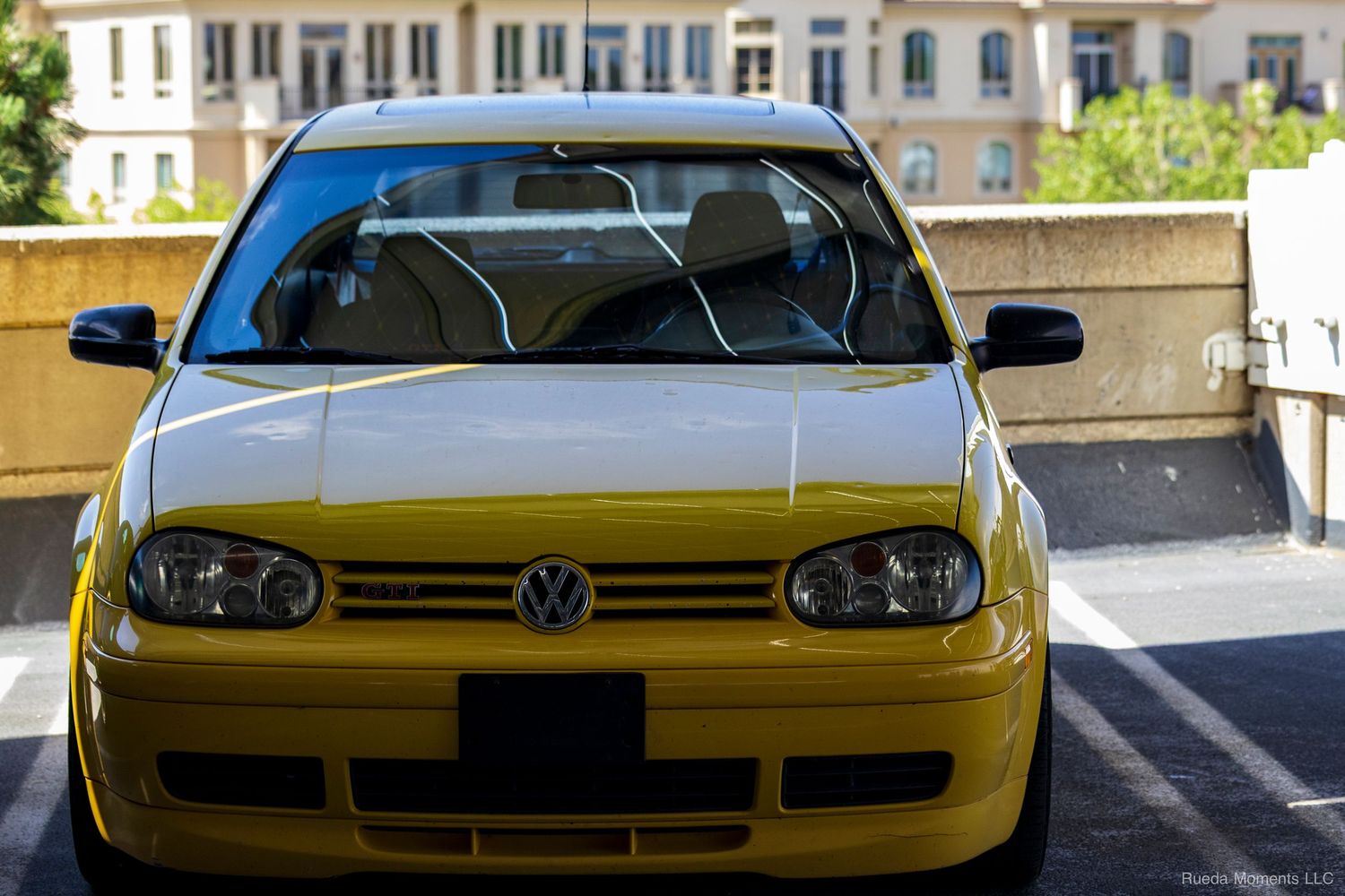 Yellow Volkswagen Golf MK4 with clean front end detail photographed in an urban parking area.