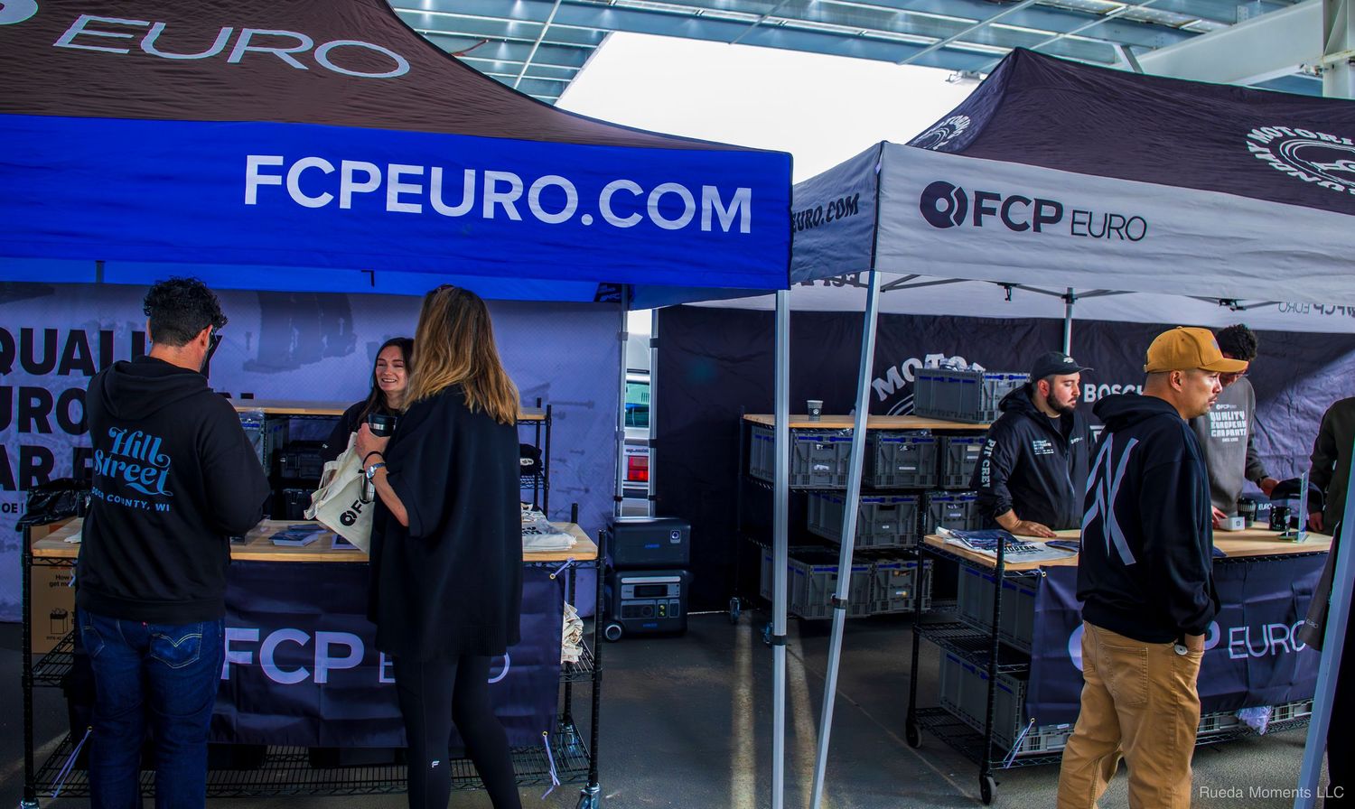 FCP Euro automotive parts vendor booth with staff and customers at a car show event.