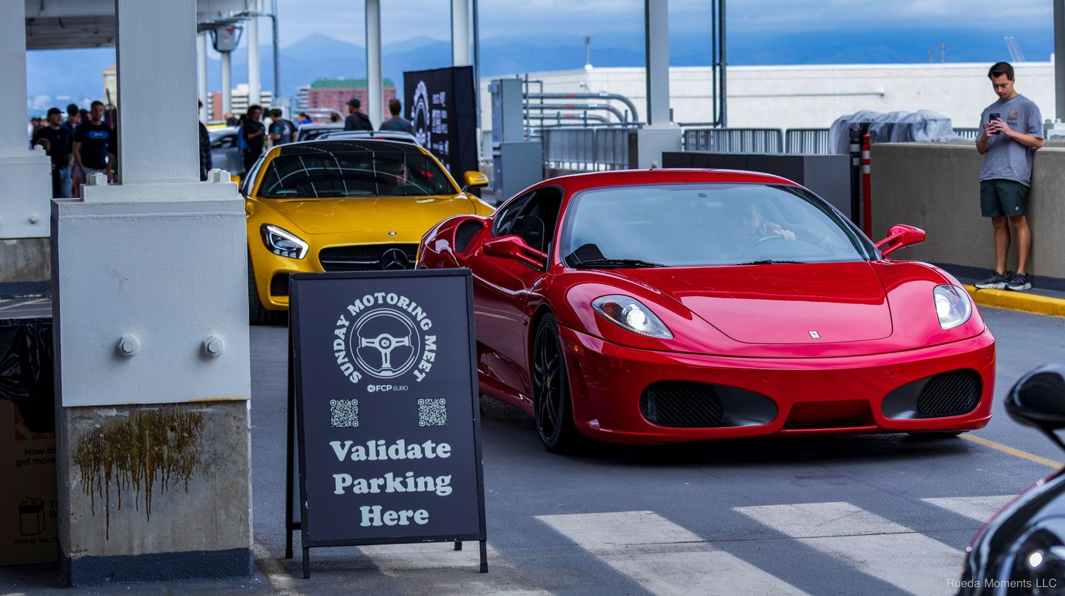 Red Ferrari F430 and yellow Mercedes-AMG parked near a validate parking sign at a meet.