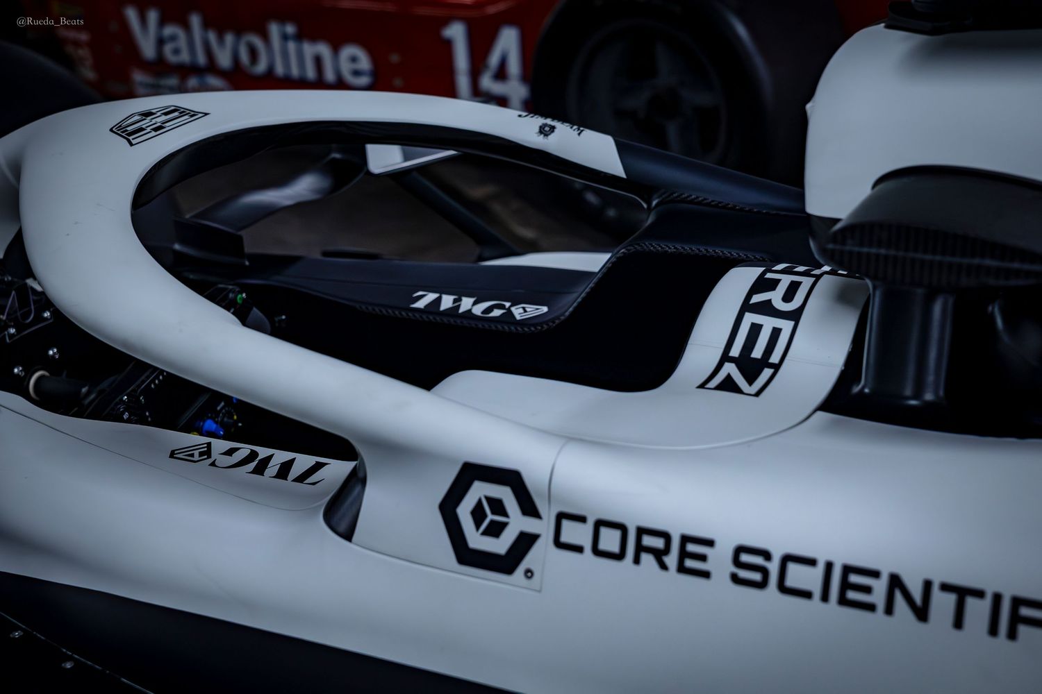 Close-up of a white race car cockpit with Core Scientific and TWG sponsorship logos.