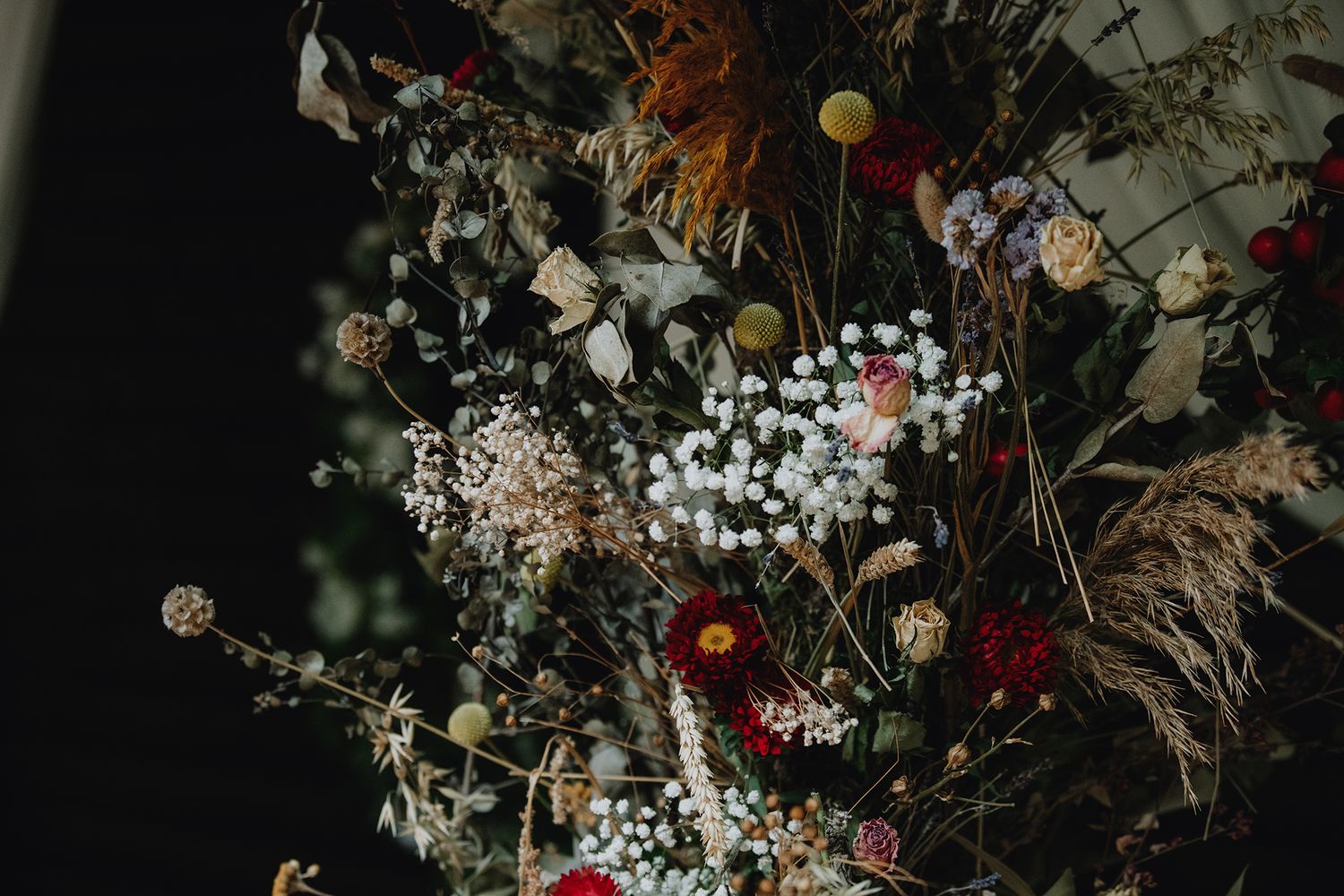 Close-up of a lush bohemian wedding floral arrangement featuring dried flowers and wildflowers.