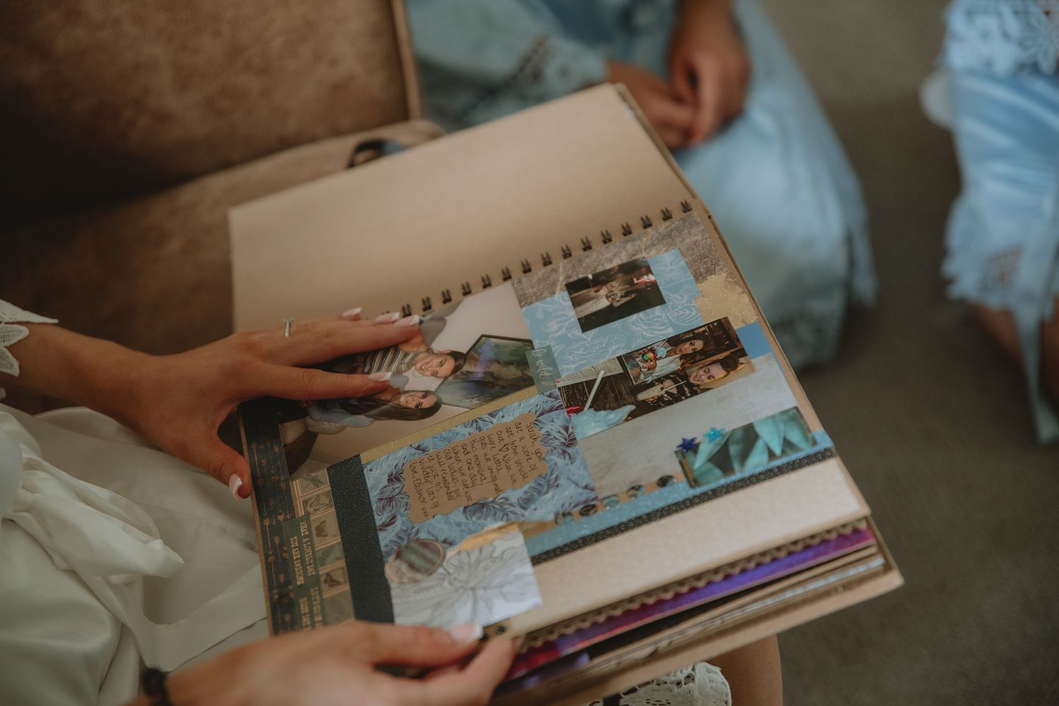 Hands holding open a decorative scrapbook with photos and colorful pages.