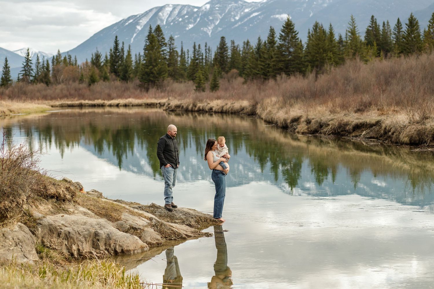 Outdoor family photo session in Fairmont Hot Springs by Mikelle Allaire taken near the river with gorgeous mountains in the background.