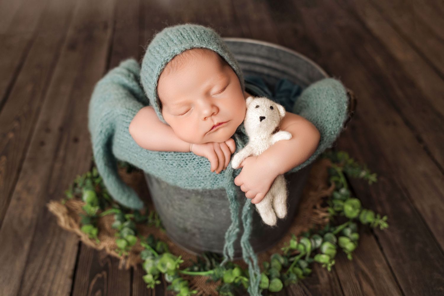 Newborn girl posed in bucket during newborn photo session at The Essence Photography Studio in Radium Hot Springs.