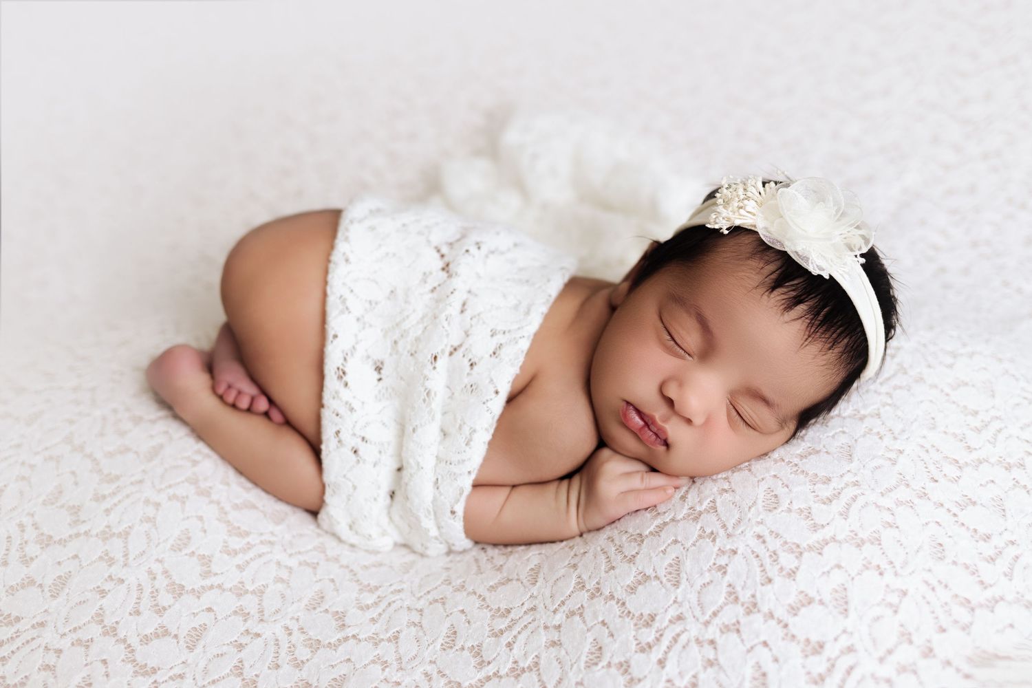Newborn baby girl curled up in 