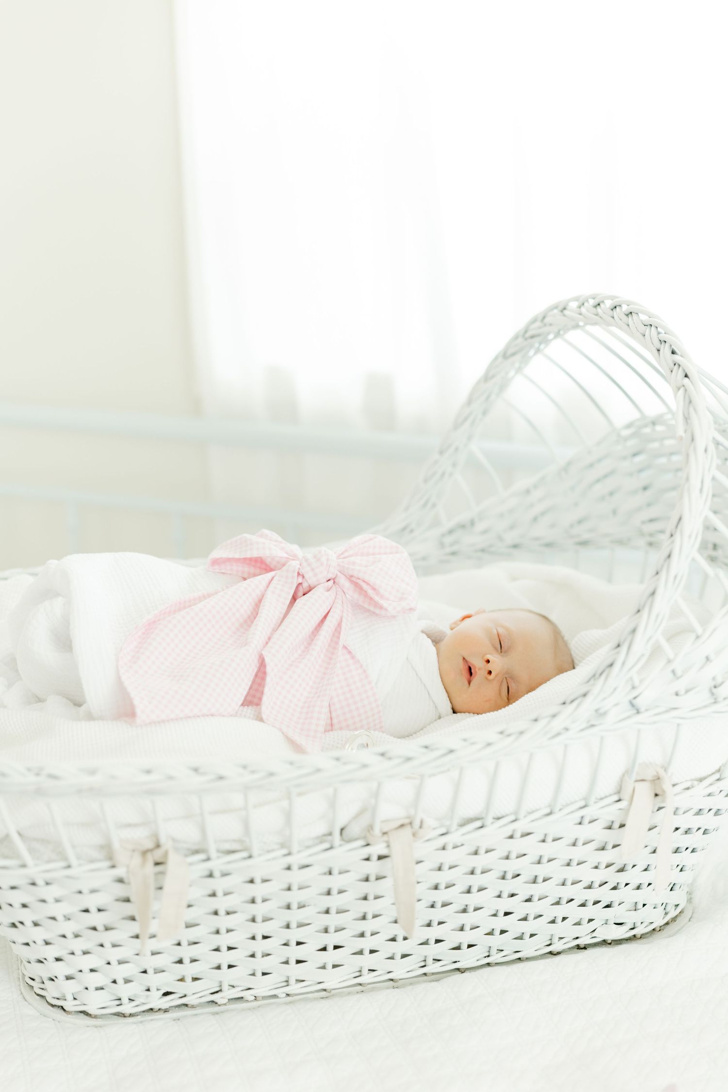 Close-up black and white photo of tiny newborn baby feet resting on a soft white blanket.