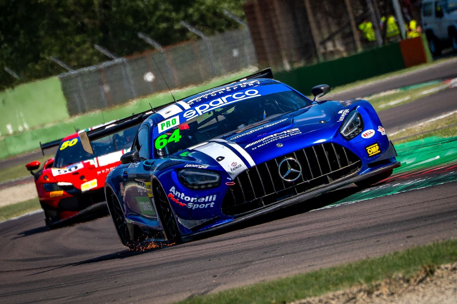 A Mercedes-AMG GT3 leads a group of cars through a corner at Imola.
