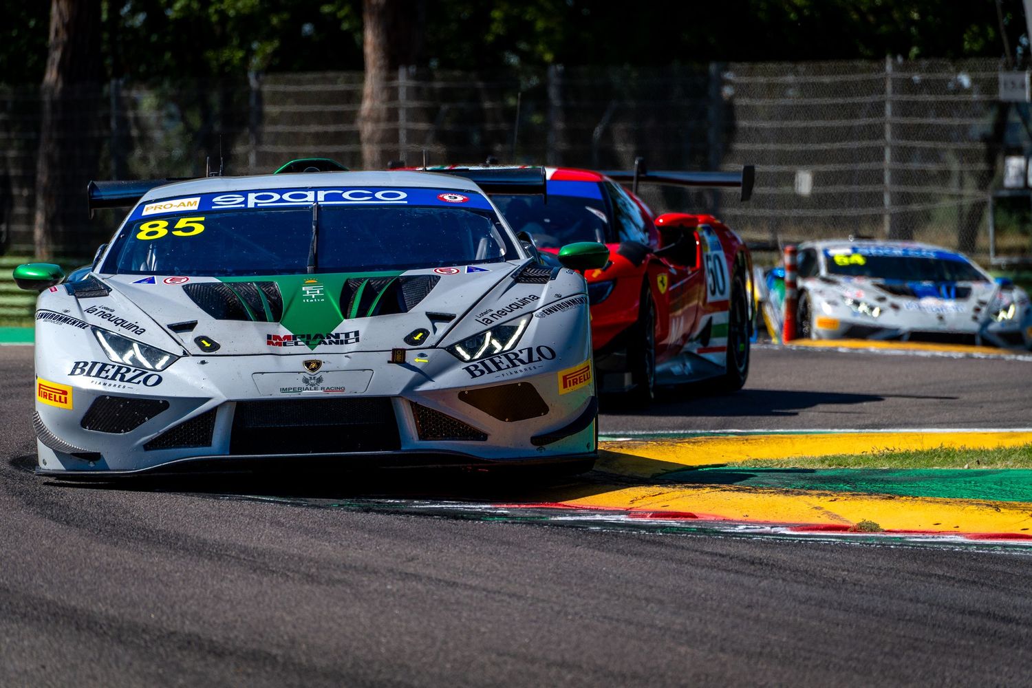 A Lamborghini Huracán GT3 leads a group of cars through a corner at Imola.