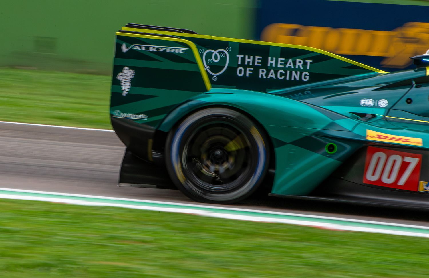 Close-up of the rear wing and wheel of a green Aston Martin Hypercar with Heart of Racing livery.